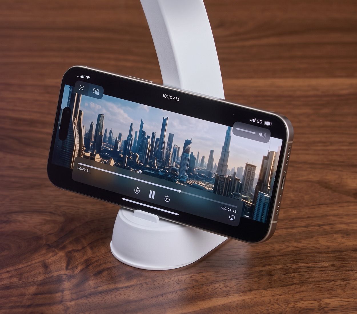 A phone stands upright in one of the white light's base holders, playing a video.