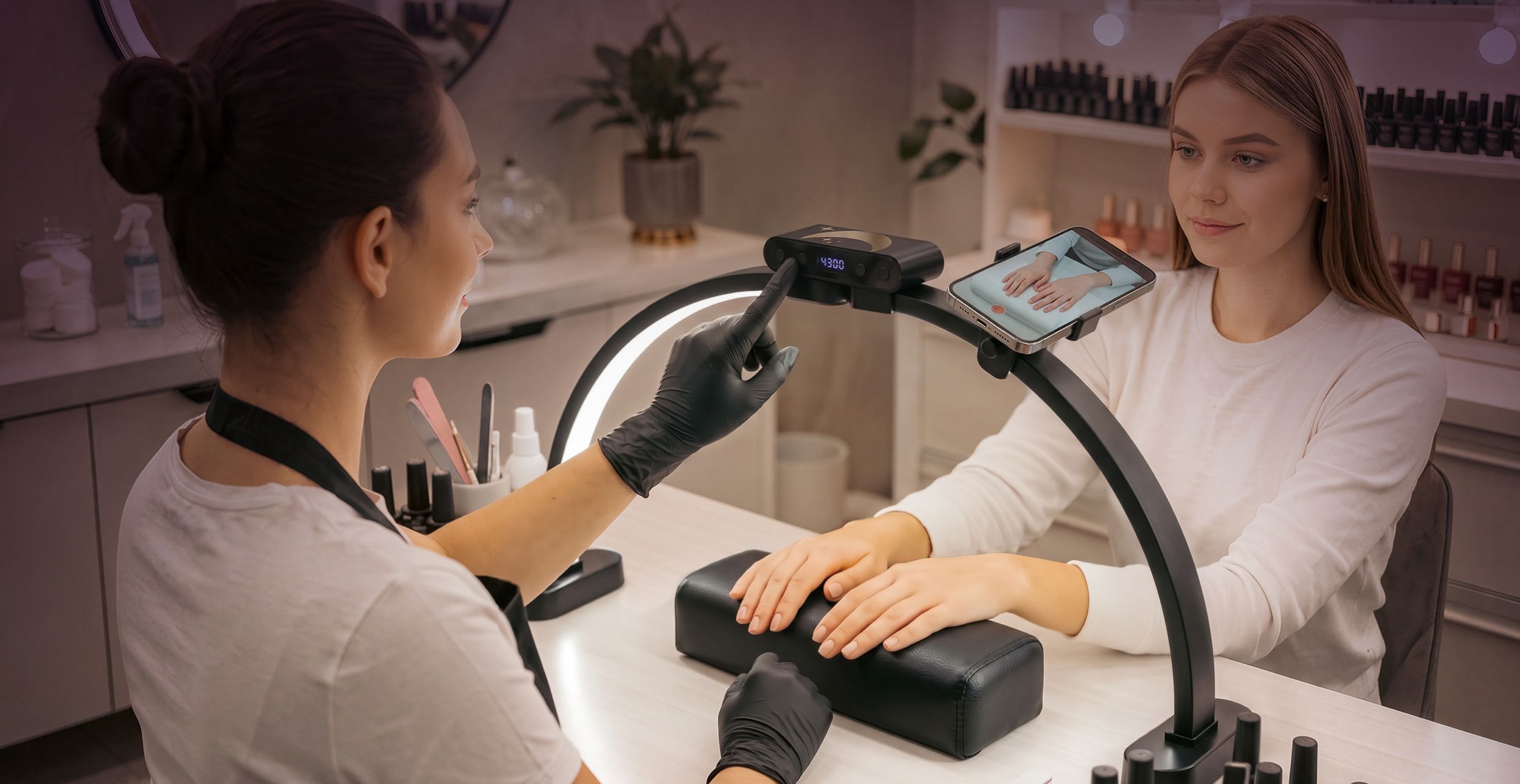 A technician in black gloves touches the control panel of the black Half-Moon Light while a client's hands rest on the arm rest.