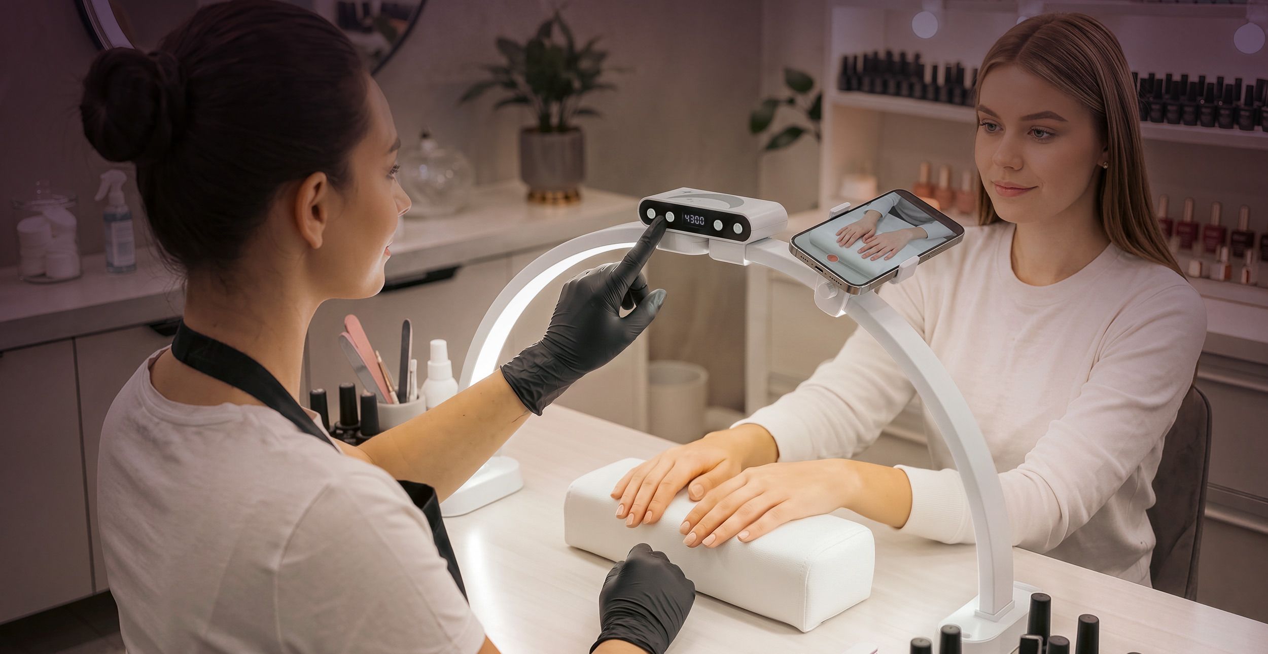 A technician in black gloves touches the control panel of the white Half-Moon Light while a client's hands rest on the arm rest.